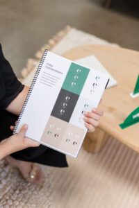 Color combinations guide showing brand color palettes with text and logos on a spiral-bound notebook.